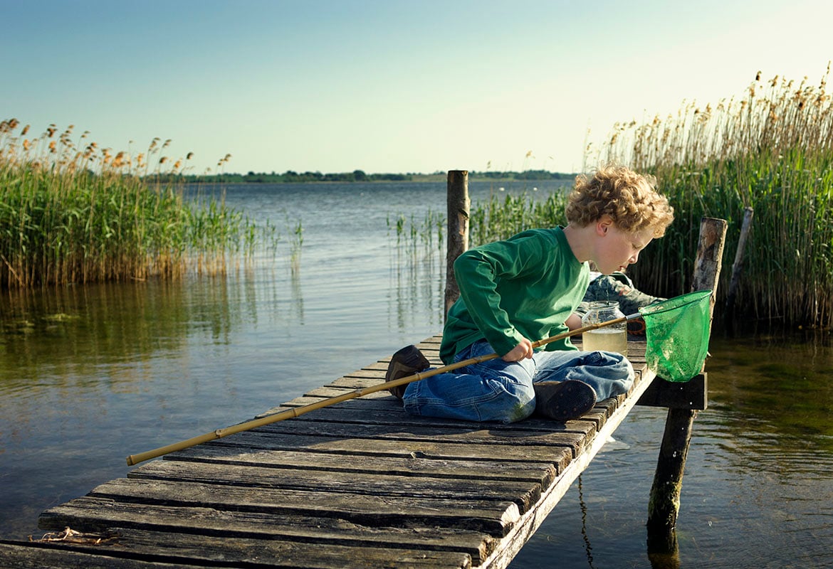 barn som fisker på brygge