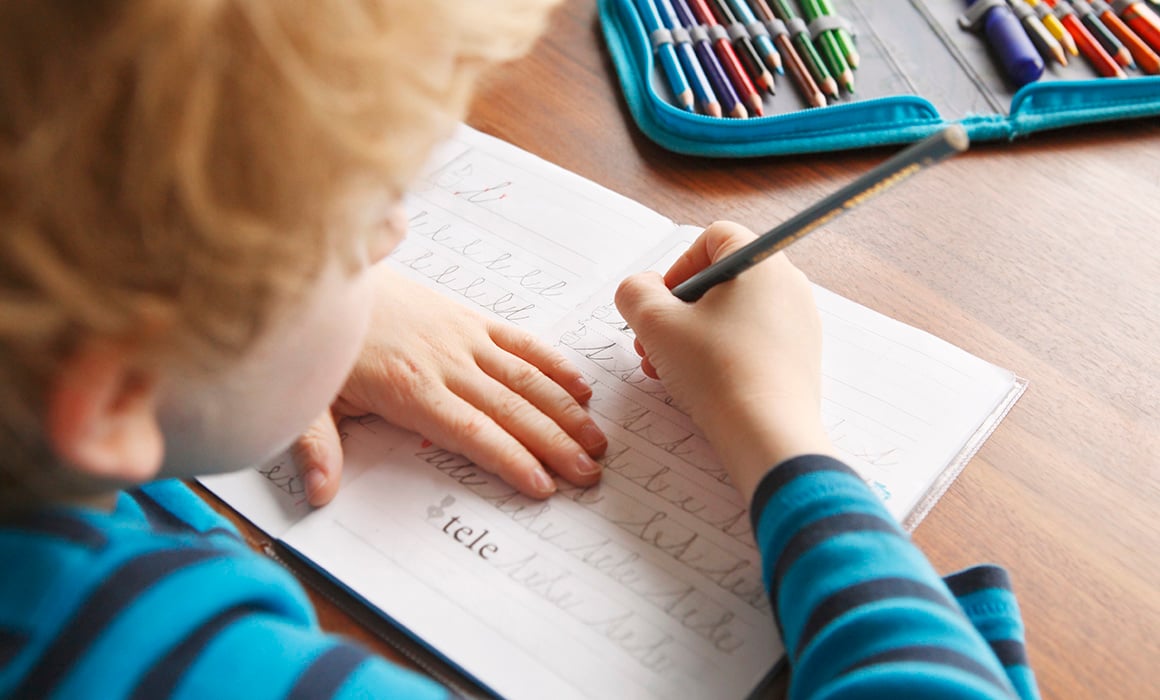 Barn som skriver i skolebok